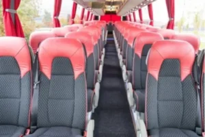 Interior view of 27-seater Bharat Benz corporate bus featuring comfortable pushback seats, wide aisle, and premium seating layout for corporate and group journeys.
