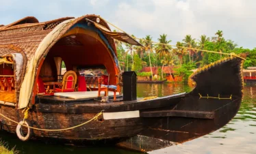 Kerala honeymoon houseboat experience showing a luxury private houseboat cruising through serene backwaters with romantic décor in Alleppey, Kerala.